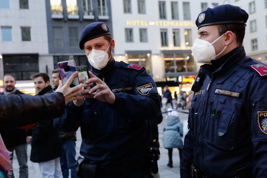 FILE - Police officers check the vaccination status of visitors during a patrol on a Christmas market in Vienna, Austria, Friday, Nov. 19, 2021. This was supposed to be the Christmas in Europe where family and friends could once again embrace holiday festivities and one another. Instead, the continent is the global epicenter of the COVID-19 pandemic as cases soar to record levels in many countries.
