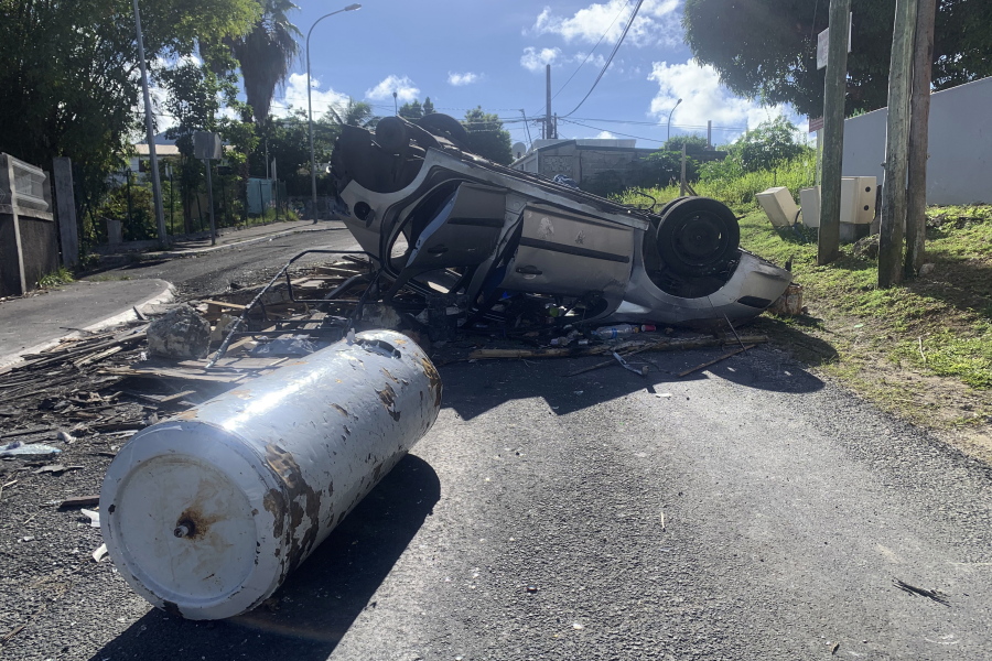 An overturned car is pictured in a s street of Le Gosier, Guadeloupe island, Sunday, Nov.21, 2021. French authorities are sending police special forces to the Caribbean island of Guadeloupe, an overseas territory of France, as protests over COVID-19 restrictions erupted into rioting. The protests have been called for by trade unions to denounce the COVID-19 health pass that is required to access restaurants and cafes, cultural venues, sport arenas and long-distance travel.