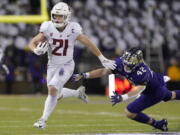 Washington State running back Max Borghi (21) evades a tackle attempt from Washington tight end Carson Smith (42) as he runs for a touchdown during the first half of an NCAA college football game, Friday, Nov. 26, 2021, in Seattle. (AP Photo/Ted S.