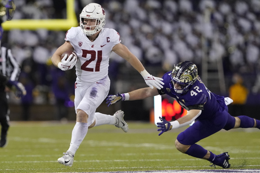 Washington State running back Max Borghi (21) evades a tackle attempt from Washington tight end Carson Smith (42) as he runs for a touchdown during the first half of an NCAA college football game, Friday, Nov. 26, 2021, in Seattle. (AP Photo/Ted S.