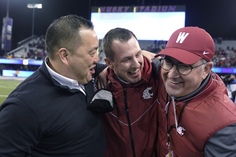 Washington State coach Jake Dickert, center, is joined by athletic director Pat Chun, left, and WSU President Kirk Schultz after WSU defeated Washington 40-13 in an NCAA college football game Friday, Nov. 26, 2021, in Seattle. (AP Photo/Ted S.