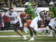 Oregon quarterback Anthony Brown (13) is pursued by Washington State defensive end Quinn Roff (20) during the third quarter of an NCAA college football game Saturday, Nov. 13, 2021, in Eugene, Ore.