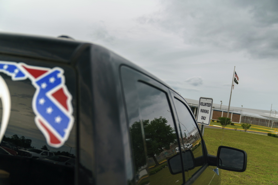FILE - A pickup truck with a Confederate flag-themed decal is parked outside the Reception and Medical Center, the state's prison hospital where new inmates are processed, in Lake Butler, Fla., Friday, April 16, 2021.