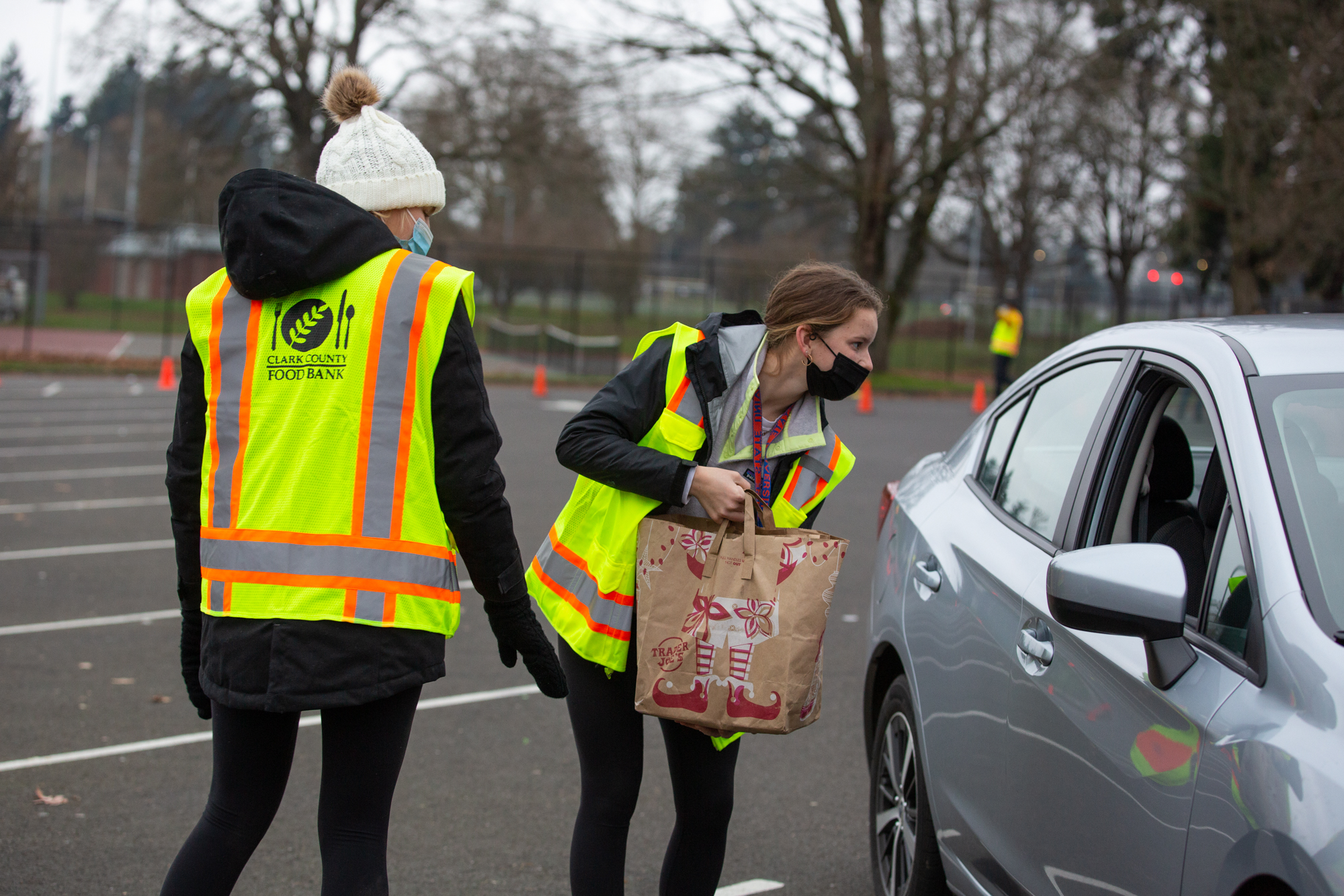 Seton Catholic High School students Cami Price, left, and Lara Carrion accept donations at a Drive & Drop food drive at Hudson's Bay High on Saturday. Price and Carrion were among a larger group of local National Honor Society students volunteering at the various drop off locations.