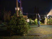 Collin Petersen of Vancouver walks around a Boy Scout-run Christmas tree lot Tuesday at Chase Bank on Northwest 78th Street.