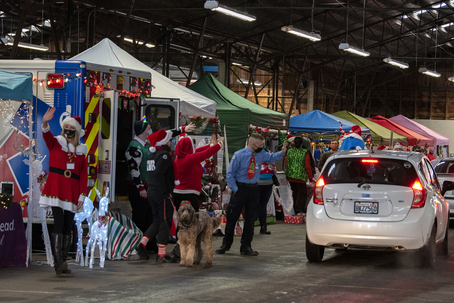 A long line of motorists drive through the second annual Caregivers Christmas, hosted by the nonprofit Loving Them Forward, at the Clark County Event Center at the Fairgrounds on Tuesday morning. The organization was able to quadruple its efforts this year, a sign of increased giving this holiday season.