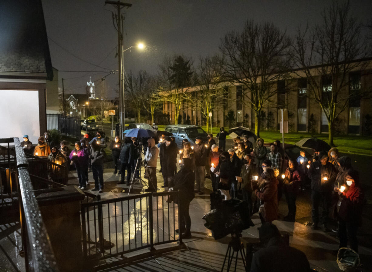 Vigil attendees hold candles and listen to speakers Tuesday at St. Paul Lutheran Church during a candlelight vigil honoring those who died while experiencing homelessness.