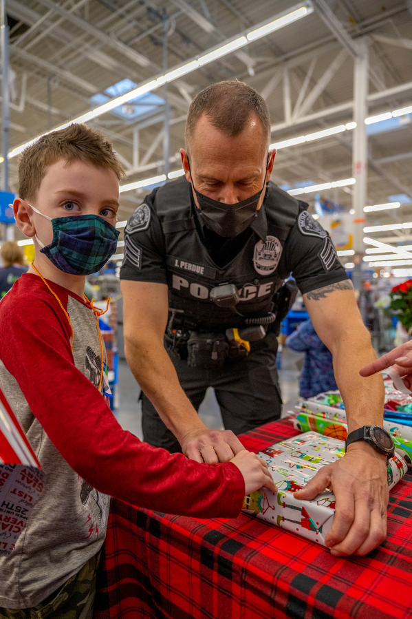 (Photo contributed by the city of Battle Ground
Nineteen kids spent the morning of Dec. 4 at the Battle Ground Walmart shopping for gifts for their families and items for themselves, accompanied by 10 Battle Ground police officers who volunteer for this special Shop with a Cop assignment.)