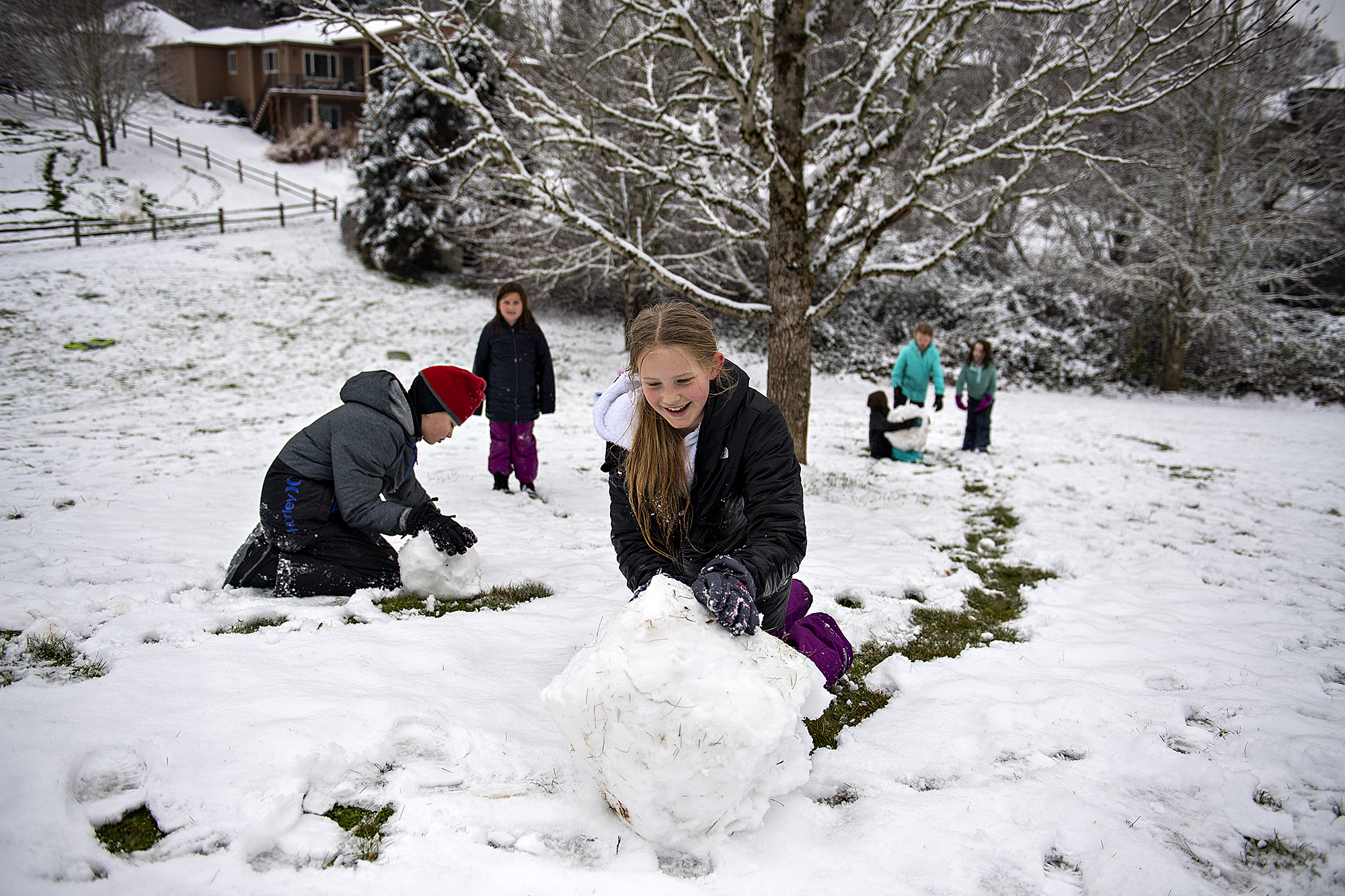Ryder Sorensen, 10, of Vancouver, red hat on left, joins Elsie Frost, 9, and others as they make the most of the snowfall at a park in Felida's Ashley Heights neighborhood on Tuesday morning, Dec. 28, 2021.
