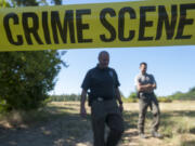 Sheriff's Detectives Joe Swenson, left, and Scott Gilberti investigate the scene after the body of a former Gypsy Jokers motorcycle club member was found in a field off Northeast 179th Street on July 1, 2015. Two members of the club were convicted in federal court this week on charges related to the murder.