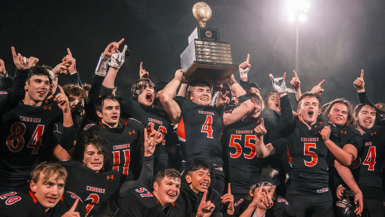 Kalama’s Jackson Esary (4) holds up the WIAA Class 2B state football trophy while surrounded by teammates after beating Napavine 16-14 on Saturday, Dec. 4, 2021, at Harry E. Lang Stadium in Lakewood.