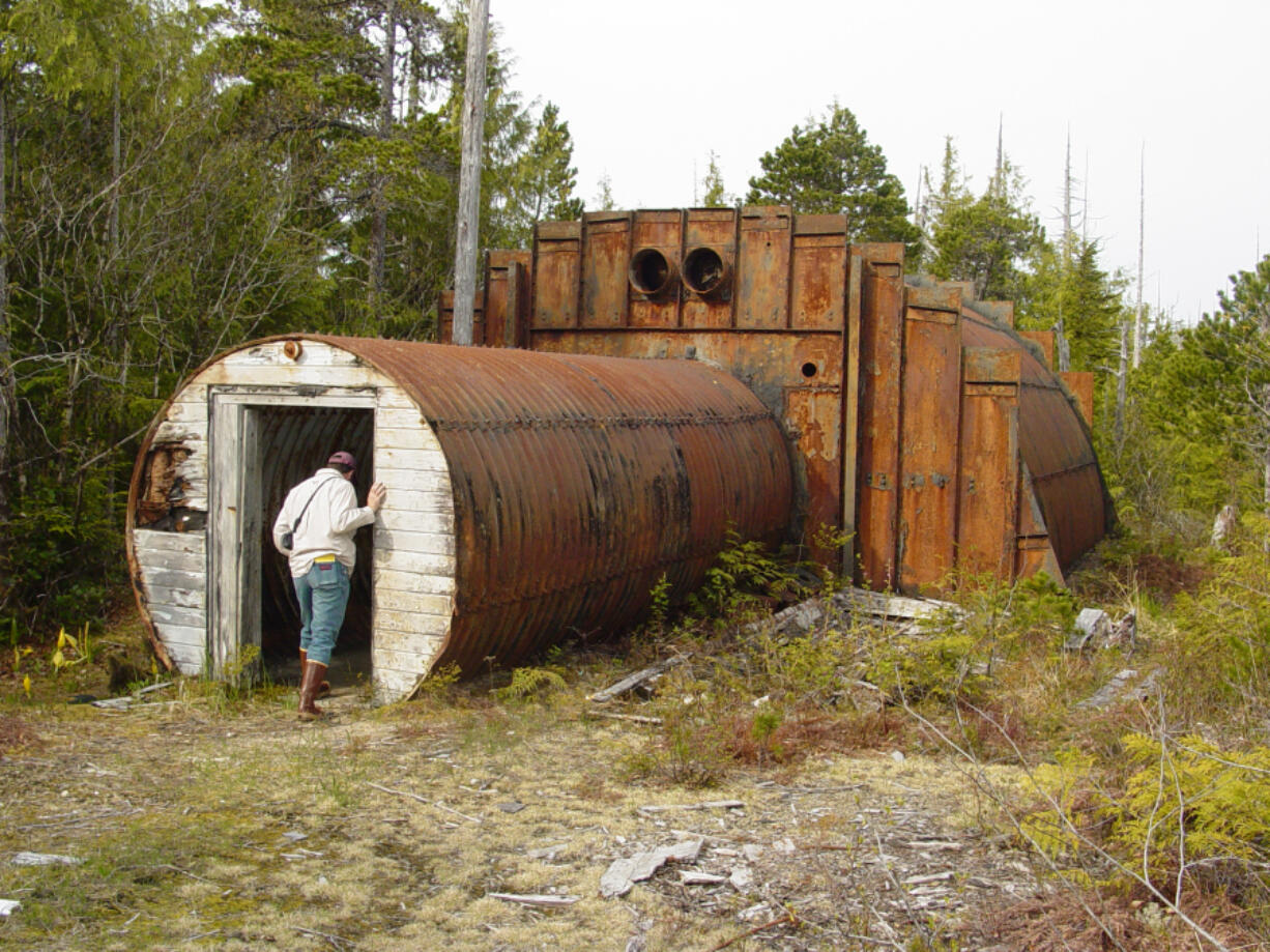 A community member peers into an abandoned military structure on Annette Island. Starting in 1940, the military and other federal agencies used the island for various purposes, leaving structures and debris behind as the land changed hands. The U.S. Army Corps of Engineers ??? Alaska District administers the contract under which the Metlakatla Indian Community performs cleanup efforts for the Native American Lands Environmental Mitigation Program. (U.S. Army Corps of Engineers ???