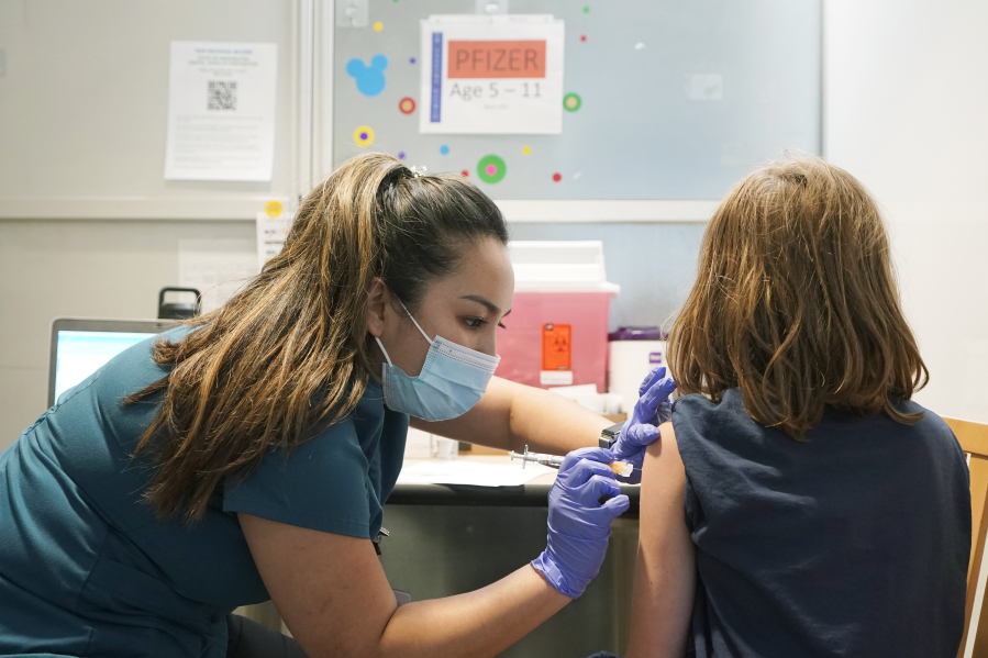 Courtney Martin, left, a nurse at the University of Washington Medical Center, gives the first shot of the Pfizer COVID-19 vaccine to Ani Hahn, 7, Tuesday, Nov. 9, 2021, in Seattle. Last week, U.S. health officials gave the final signoff to Pfizer's kid-size COVID-19 shot, a milestone that opened a major expansion of the nation's vaccination campaign to children as young as 5. (AP Photo/Ted S.