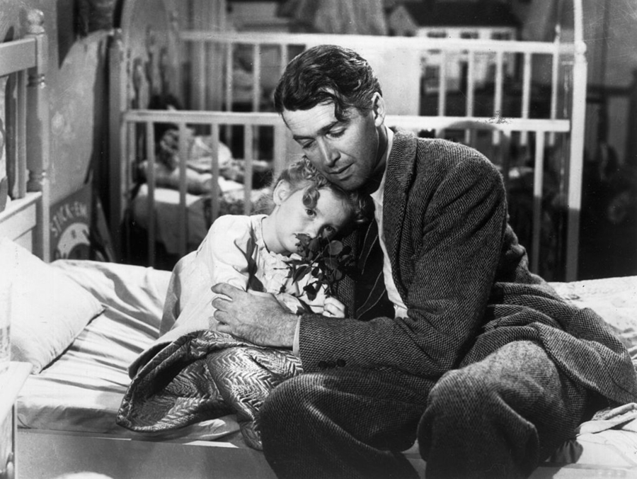 Jimmy Stewart as George Bailey, hugs actor Karolyn Grimes, who plays his daughter Zuzu, in "It's a Wonderful Life." (Hulton Archive/Getty Images)
