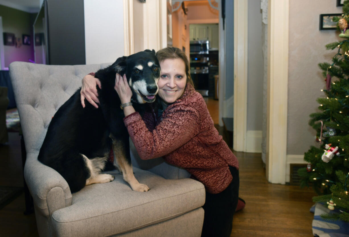 Anne Burrows poses for a portrait with her dog Ruby at her home Tuesday, Dec. 7, 2021, in Ben Avon, Pennsylvania.