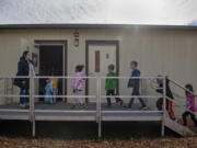 Substitute teacher Alison Davies, left, holds the door while leading second-graders back to their classroom at Union Ridge Elementary School on Nov. 17.