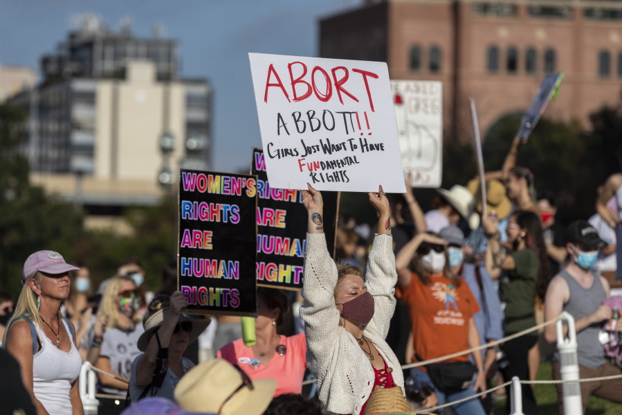 FILE - People attend the Women's March ATX rally, Saturday, Oct., 2, 2021, at the Texas State Capitol in Austin, Texas.  An expected decision by the U.S. Supreme Court in the coming year to severely restrict abortion rights or overturn Roe v. Wade entirely is setting off a renewed round of abortion battles in state legislatures.