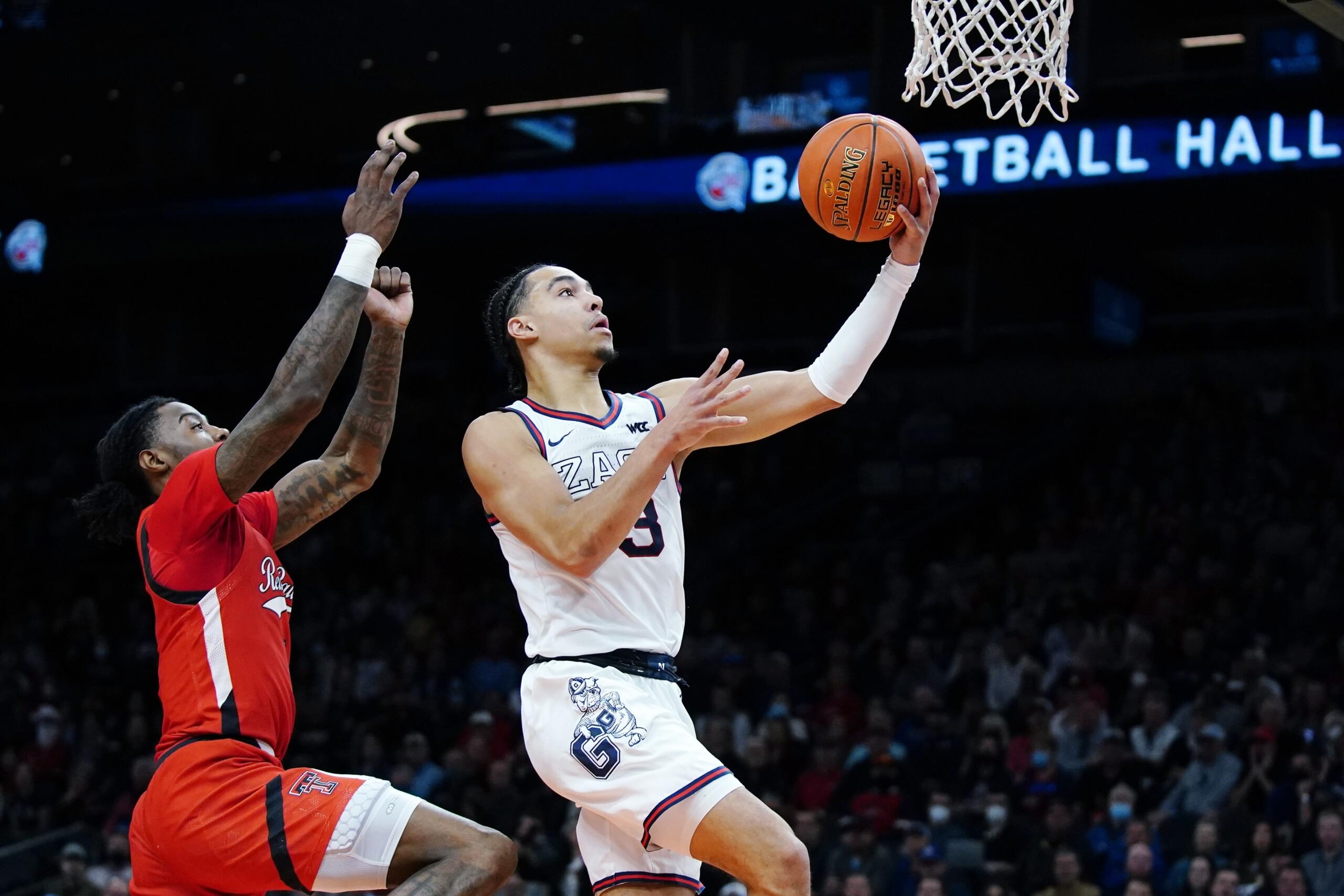Gonzaga guard Andrew Nembhard, right, goes up for a shot against Texas Tech guard Davion Warren, left, during the first half of an NCAA college basketball game at the Jerry Colangelo Classic Saturday, Dec. 18, 2021, in Phoenix. (AP Photo/Ross D.