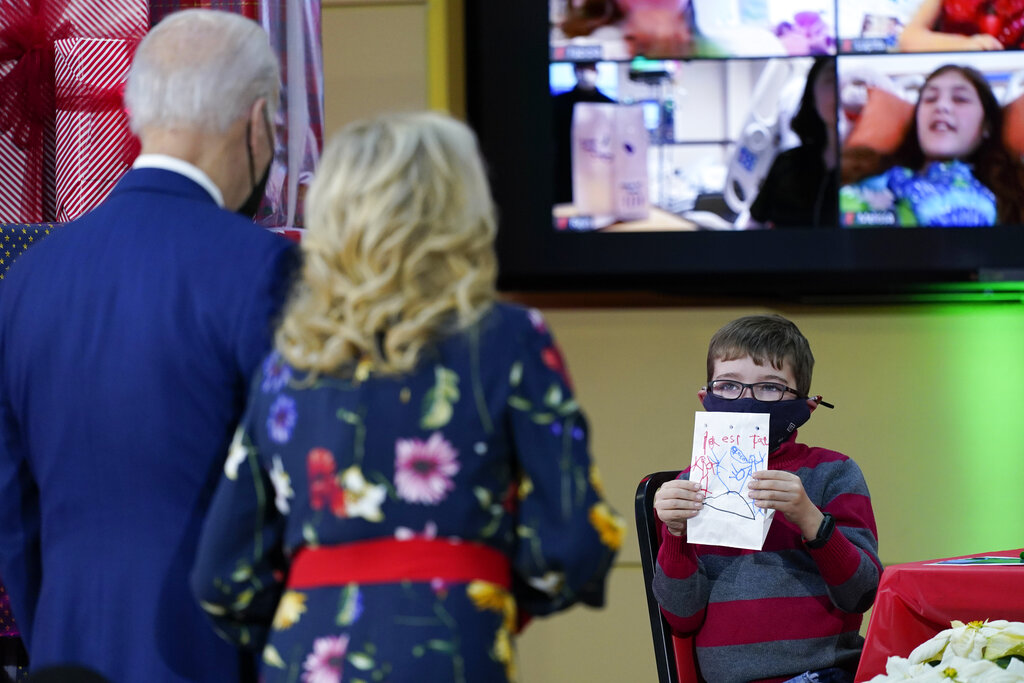 A patient at Children's National Hospital displays a lantern they made to President Joe Biden and first lady Jill Biden as they visit patients in Washington, Friday, Dec. 24, 2021.