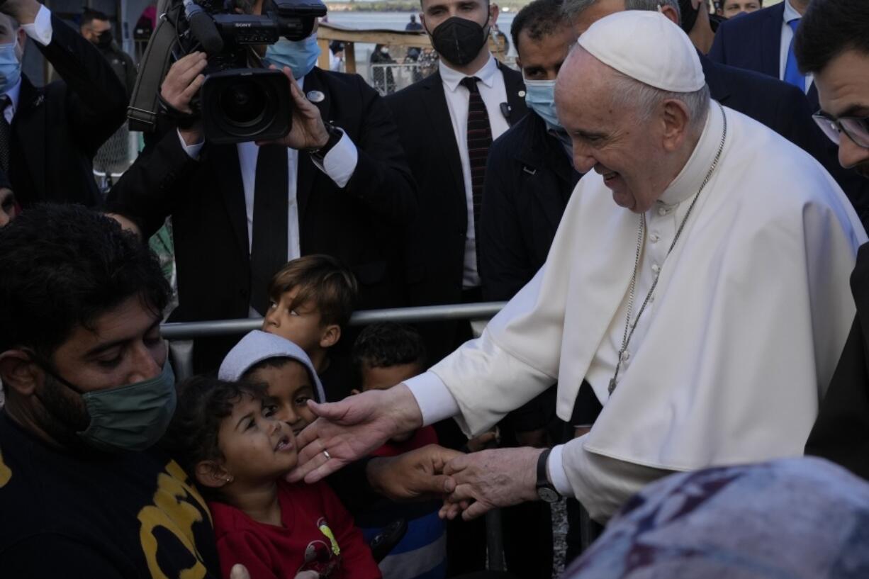 Pope Francis meets migrants during his visit at the Karatepe refugee camp, on the northeastern Aegean island of Lesbos, Greece, Sunday, Dec. 5, 2021. Pope Francis is offering comfort migrants at a refugee camp on the Greek island of Lesbos.