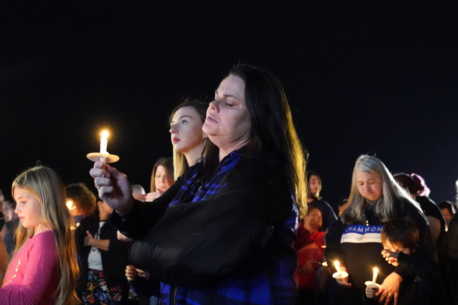 People participate in a candlelight vigil in the aftermath of tornadoes that tore through the region several days earlier, in Mayfield, Ky., late Tuesday, Dec. 14, 2021.