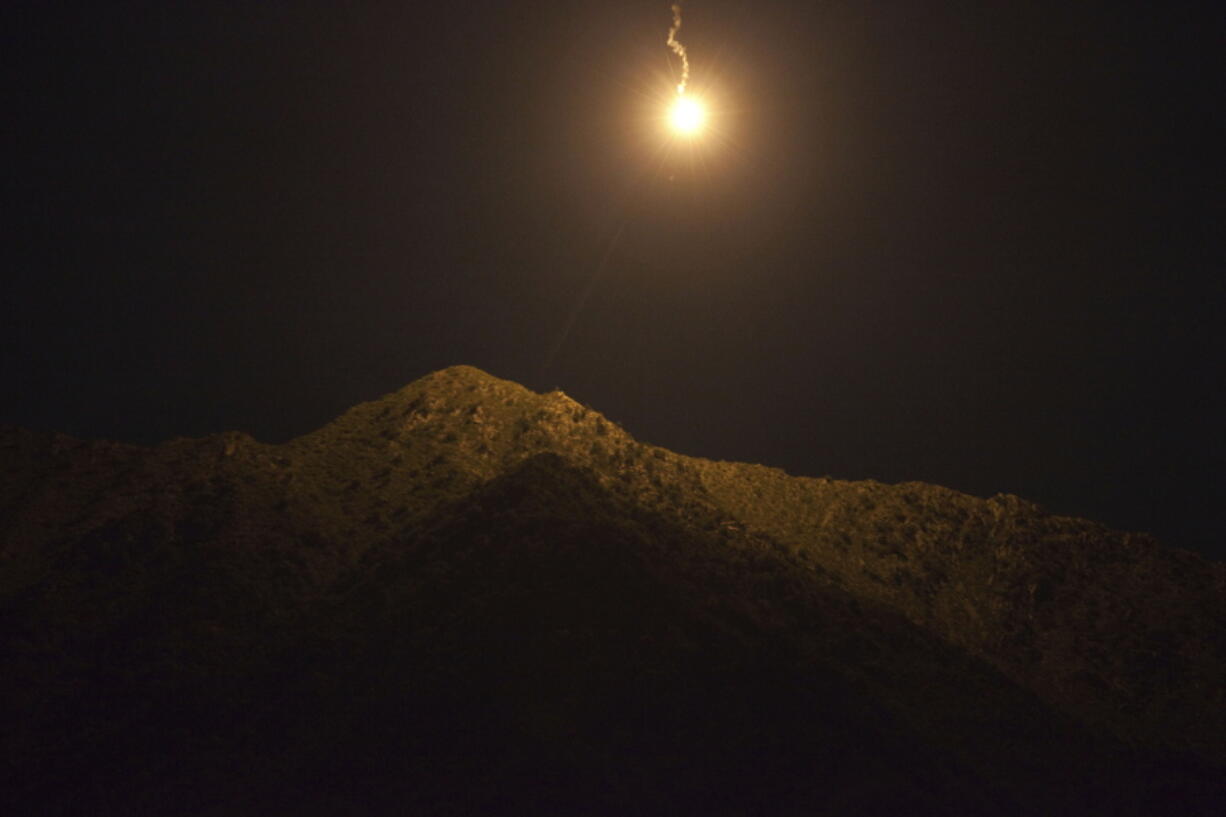 FILE - An illumination round falls during a night mission by soldiers of the U.S. Army, Sept. 14, 2011, in Kunar province, Afghanistan. Two men who forged deep bonds of friendship while serving in the Army in Afghanistan would be arrested in 2018 for a scheme to steal weapons and explosives from an armory at Fort Bragg, North Carolina, and sell them. An Associated Press investigation into lost and stolen military weapons has shown that insider thefts remain a serious concern.