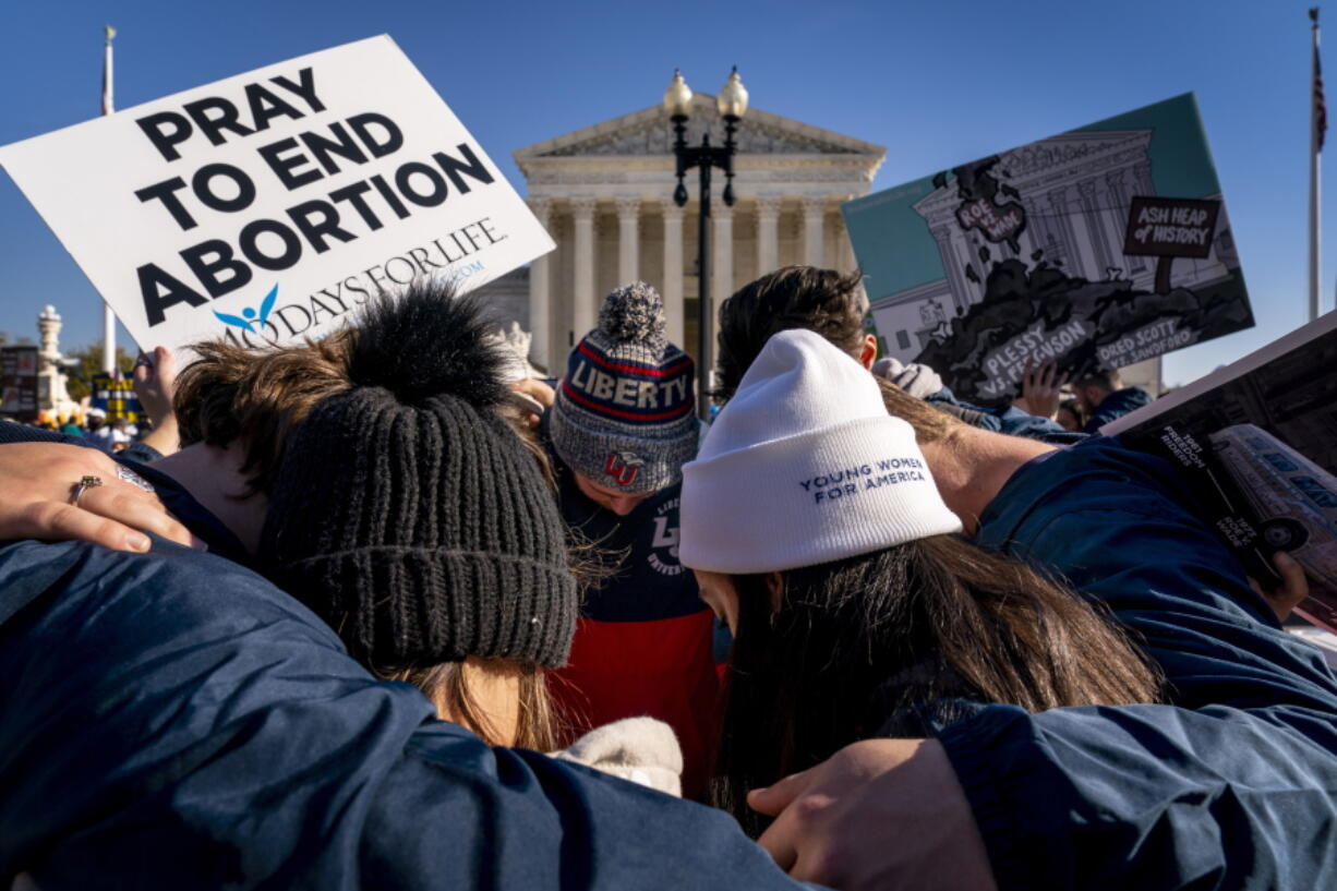 FILE - A group of anti-abortion protesters pray together in front of the U.S. Supreme Court, Dec. 1, 2021, in Washington, as the court hears arguments in a case from Mississippi, where a 2018 law would ban abortions after 15 weeks of pregnancy, well before viability. As the Supreme Court court weighs the future of the landmark 1973 Roe v. Wade decision, a resurgent anti-abortion movement is looking to press its advantage in state-by-state battles while abortion-rights supporters prepare to play defense.