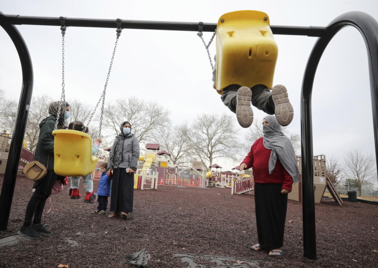Afghan refugee mothers and children play in a park in Liberty Village on Joint Base McGuire-Dix- Lakehurst in Trenton, N.J., Thursday, Dec. 2, 2021.