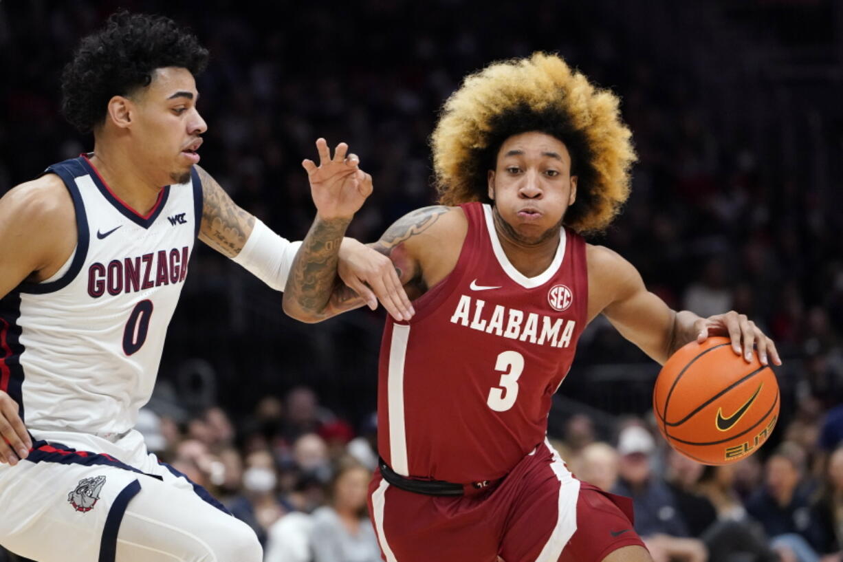 Alabama's JD Davison (3) tries to drive past Gonzaga's Julian Strawther (0) during the first half of an NCAA college basketball game Saturday, Dec. 4, 2021, in Seattle.