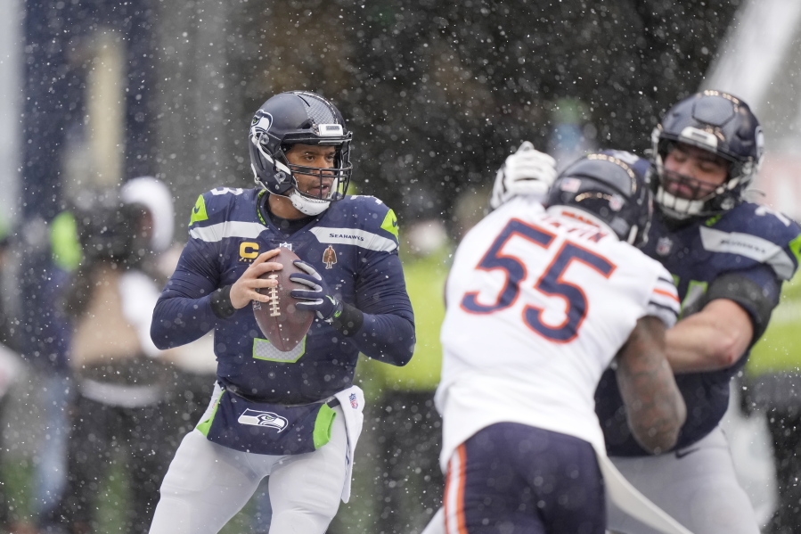 Seattle Seahawks quarterback Russell Wilson, left, looks to pass against the Chicago Bears  on Sunday in Seattle. Wilson hasn't led a late game-winning drive this season.