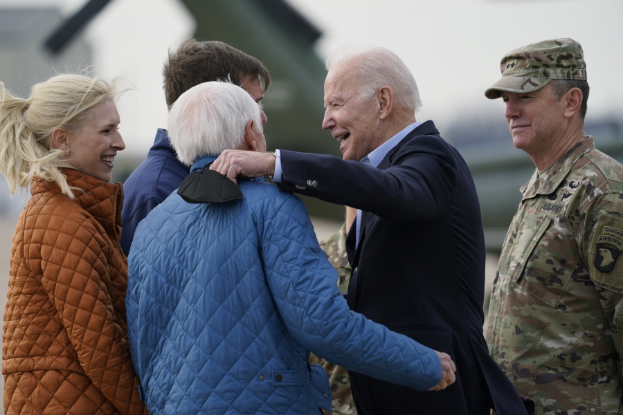 President Joe Biden greets former Gov. Steve Beshear, second from left, Kentucky Gov. Andy Beshear and his wife Britainy Beshear, left, as he arrives in Fort Campbell, Ky., Wednesday, Dec. 15, 2021, to survey storm damage from tornadoes and extreme weather. Gen. Joseph P McGee, Commanding General, 101st Airborne Division is at right.