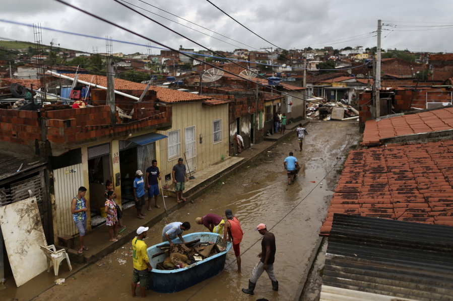 Residents clean out their flooded homes in Itapetinga, Bahia state, Brazil, on Tuesday. Two dams broke Sunday in northeastern Brazil, threatening worse flooding in a rain-drenched region that has already seen thousands of forced to flee their homes.