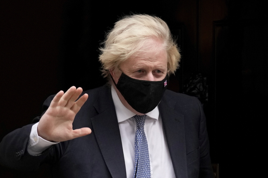 British Prime Minister Boris Johnson waves at the media as he leaves 10 Downing Street to attend the weekly Prime Minister's Questions at the Houses of Parliament, in London, Wednesday, Dec. 8, 2021.