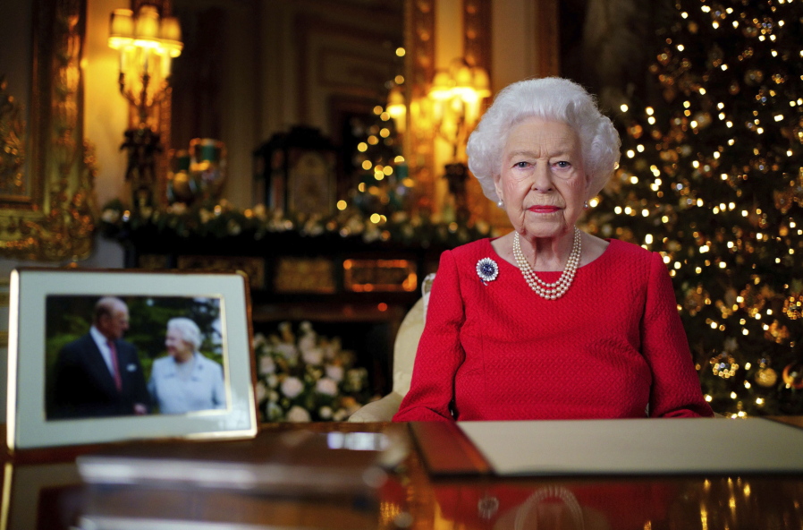 In this undated photo issued on Thursday Dec. 23, 2021, Britain's Queen Elizabeth II records her annual Christmas broadcast in Windsor Castle, Windsor, England. The photograph at left shows The Queen and Prince Philip taken in 2007 at Broadlands to mark their Diamond wedding anniversary.