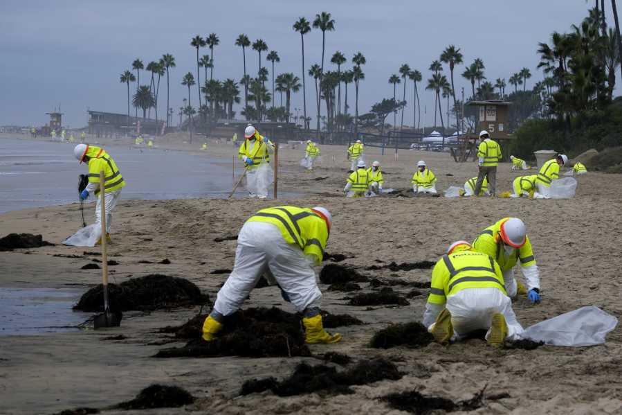 Workers clean the contaminated beach in Corona Del Mar after an oil spill off the Southern California coast Oct. 7.
