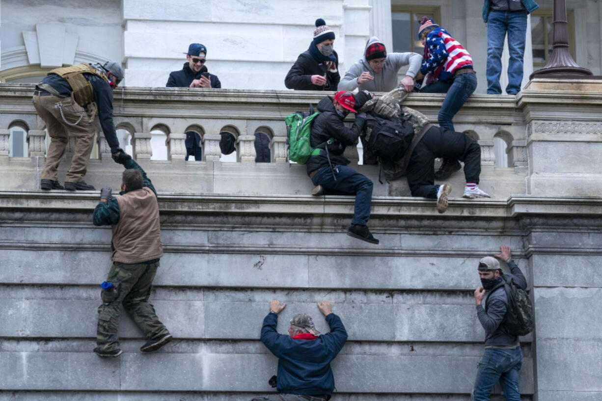 FILE - Insurrections loyal to President Donald Trump climb the west wall of the the U.S. Capitol, Jan. 6, 2021, in Washington. For many rioters who stormed the U.S. Capitol, self-incriminating messages, photos and videos that they broadcast on social media before, during and after the Jan. 6 insurrection are influencing even the sentences in their criminal cases. Among the biggest takeaways from the Justice Department'??s prosecution of the Jan. 6 insurrection is how large a role social media has played, with much of the most damning evidence coming from rioters own words and videos.