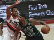 Boston Celtics guard Marcus Smart, right, drives against Portland Trail Blazers guard CJ McCollum, left, during the first half of an NBA basketball game in Portland, Ore., Saturday, Dec. 4, 2021.