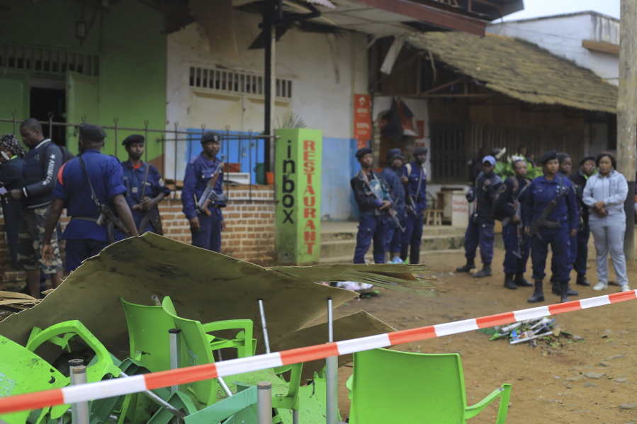 An area is cordoned off as police officers inspect the scene of a bomb explosion in Beni, eastern Congo Sunday Dec. 26, 2021. A bomb exploded at a restaurant Saturday as patrons gathered on Christmas Day in an eastern Congolese town where Islamic extremists are known to be active.