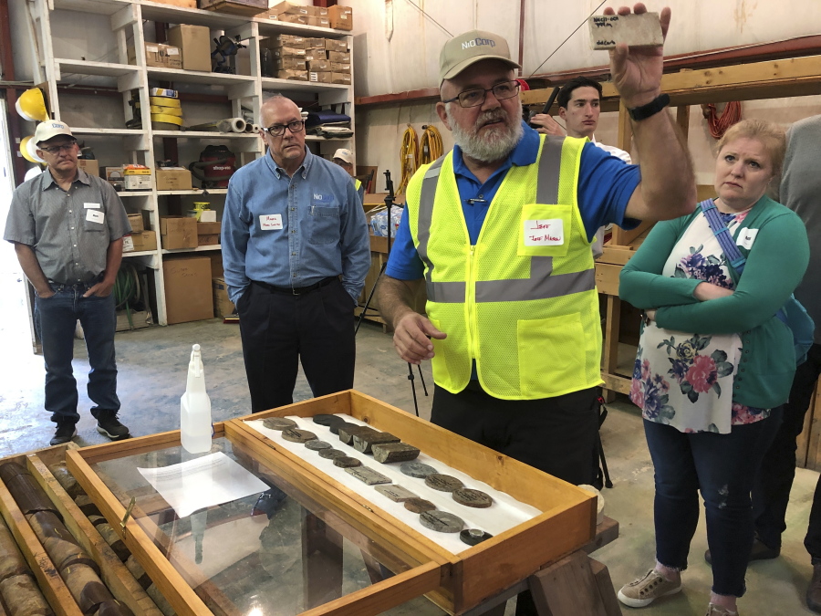 NioCorp Corporate Controller Jeff Mason shows investors a rock sample while the company's CEO Mark Smith listens, Oct. 6, 2021 in Elk Creek, Neb. The company hopes to build a mine in southeast Nebraska to extract rare minerals if it can raise $1 billion.