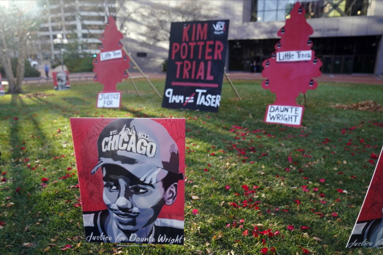 Posters stand on the south lawn Tuesday, Nov. 30, 2021 at the Hennepin County Government Center in Minneapolis where jury selection begins for former suburban Minneapolis police officer Kim Potter, who says she meant to grab her Taser instead of her handgun when she shot and killed motorist Daunte Wright.