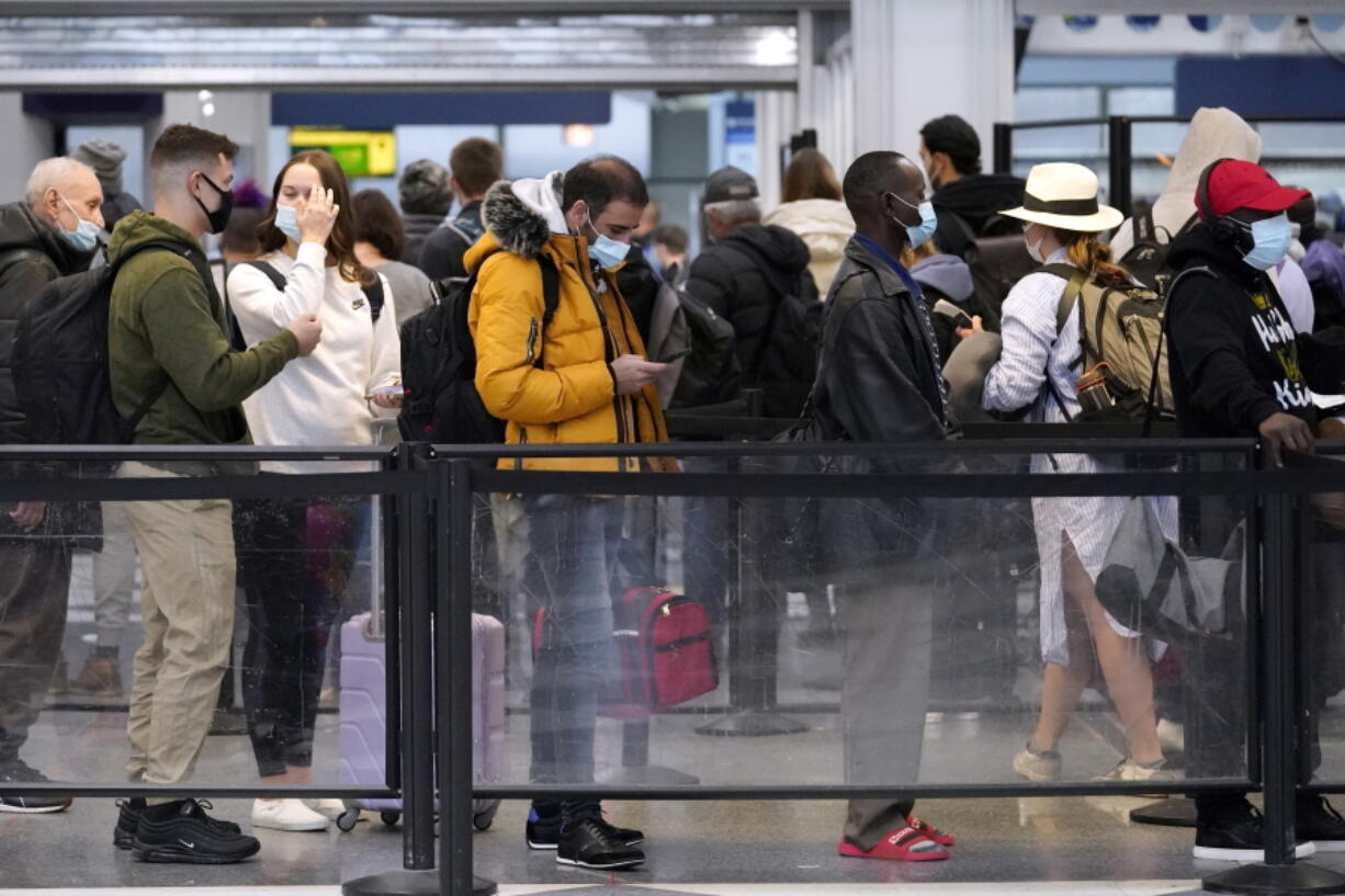 Travelers line up for flights at O'Hare International Airport in Chicago, Thursday, Dec. 30, 2021. (AP Photo/Nam Y.