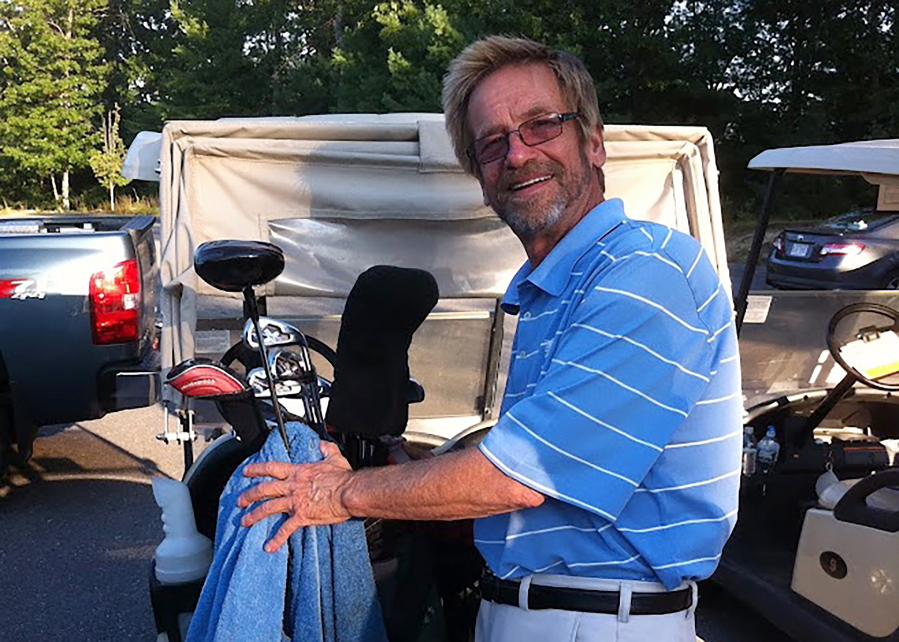 In this photo provided by Bob Van Wert, Tom Randele, whose real name according to authorities is Ted Conrad, tends to golf clubs, in September 2012, in Ayer, Mass. Conrad, a former Ohio bank teller-turned-thief, lived for decades under a different name in suburban Boston. Conrad died in May 2021.