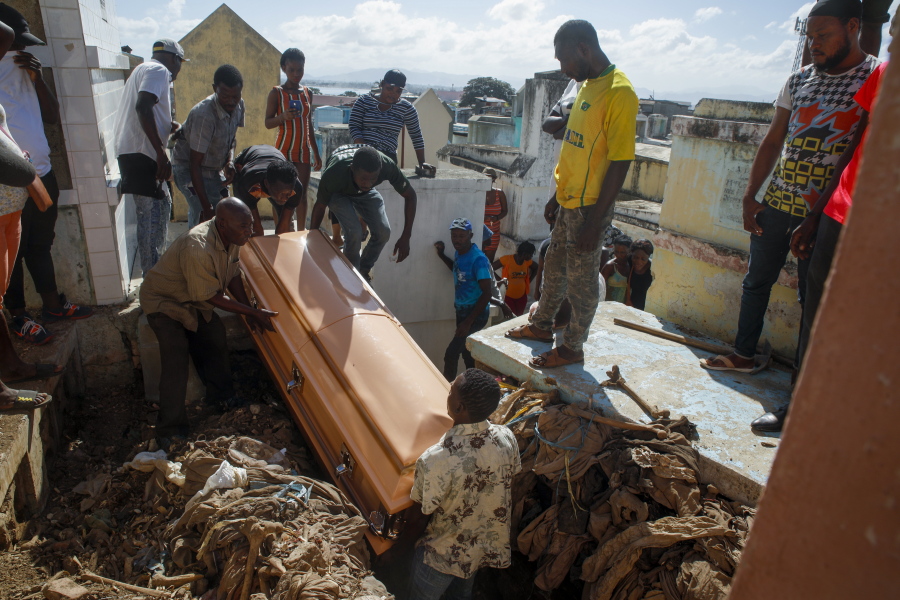 Relatives bury a woman who died in the hospital from her burn injuries caused by a gasoline truck that overturned and exploded, killing dozens in Cap-Haitien Haiti, Wednesday, Dec. 15, 2021.
