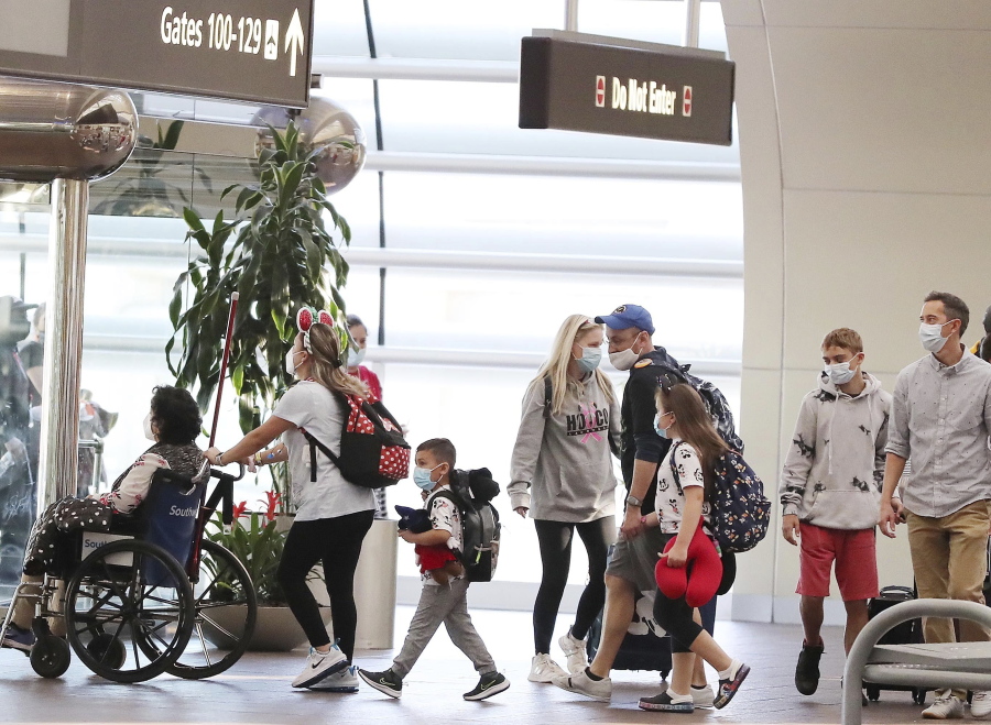 Travelers walk through Terminal A at Orlando International Airport on Christmas Day, Saturday, Dec. 25, 2021. (Stephen M.