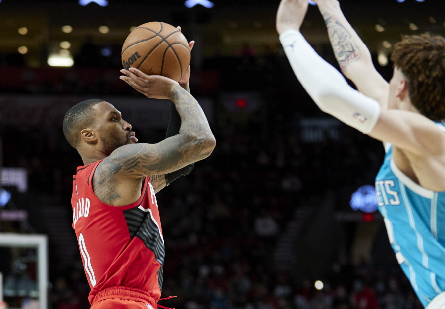 Portland Trail Blazers guard Damian Lillard, left, shoots over Charlotte Hornets guard LaMelo Ball during the second half of an NBA basketball game in Portland, Ore., Friday, Dec. 17, 2021.