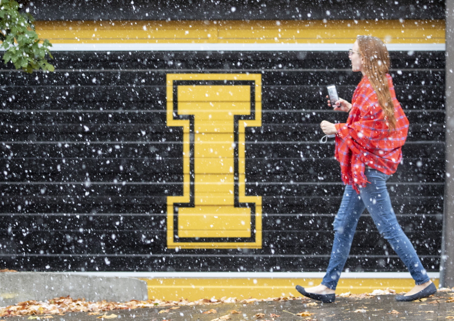 FILE - A woman walks across the University of Idaho campus during a snowstorm of the season on Oct. 23, 2020, in Moscow, Idaho.