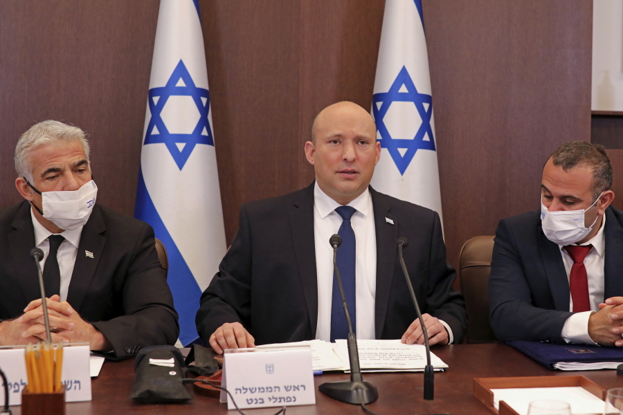 Israeli Prime Minister Naftali Bennett, center, chairs a weekly cabinet meeting, at the prime minister's office in Jerusalem, Sunday, Dec. 5, 2021.  Bennett on Sunday urged world powers to take a hard line against Iran in negotiations to curb the country's nuclear program, as his top defense and intelligence officials headed to Washington amid the flailing talks.