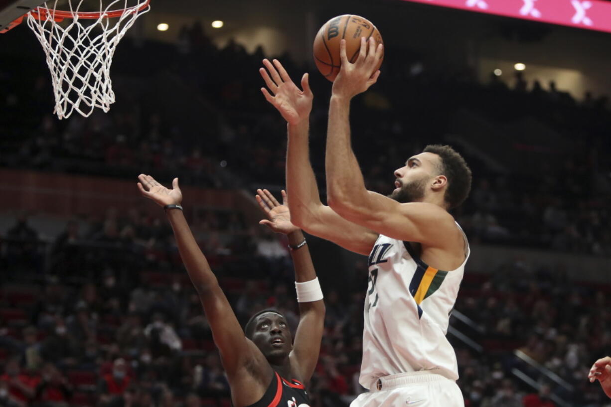 Utah Jazz center Rudy Robert shoots over Portland Trail Blazers forward Tony Snell during the first half of an NBA basketball game in Portland, Ore., Wednesday, Dec. 29, 2021.