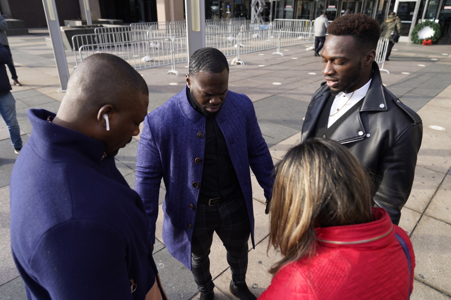 Abimbola Osundairo, right, prays with his brother Olabinjo Osundairo, center, a bodyguard, left, and their attorney Gloria Schmidt Rodriguez, upon their arrival at the Leighton Criminal Courthouse on day four of actor Jussie Smollett's trial Thursday, Dec. 2, 2021, in Chicago. Smollett is accused of lying to police when he reported he was the victim of a racist, anti-gay attack in downtown Chicago nearly three years ago.