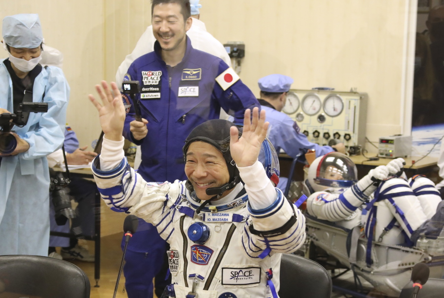 In this photo released by the Roscosmos Space Agency, spaceflight participant Yusaku Maezawa of Japan, member of the main crew of the new Soyuz mission to the International Space Station (ISS) gestures prior the launch at the Russian leased Baikonur cosmodrome, Kazakhstan, Wednesday, Dec. 8, 2021.